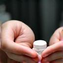 Close-up of hands exchanging a small wellness product, representing a product vendor partnership.